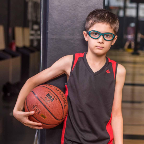 Child wearing protective sports eyewear during a basketball activity.